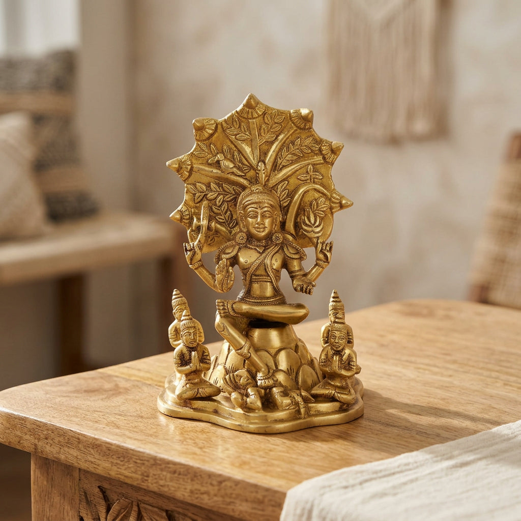 Brass Dakshinamurti statue seated beneath an ornate tree-inspired backdrop with detailed sculpting-artycraftz.com