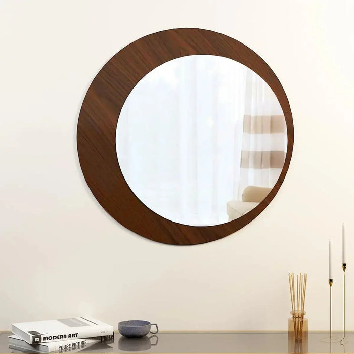 Round wooden-framed mirror on a wall with a minimal decor setup.