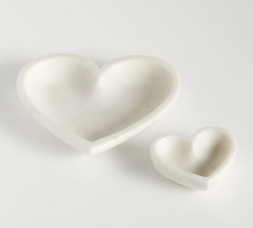 Two heart-shaped ceramic dishes on a light gray background